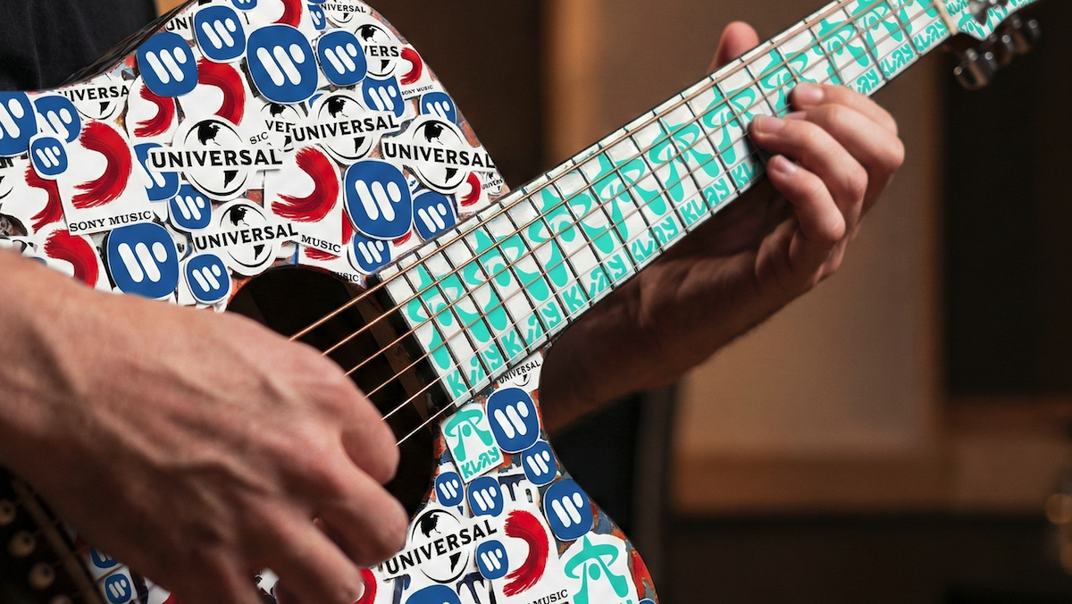 Hands strum a guitar covered in labels from major record companies, symbolizing AI music innovation.